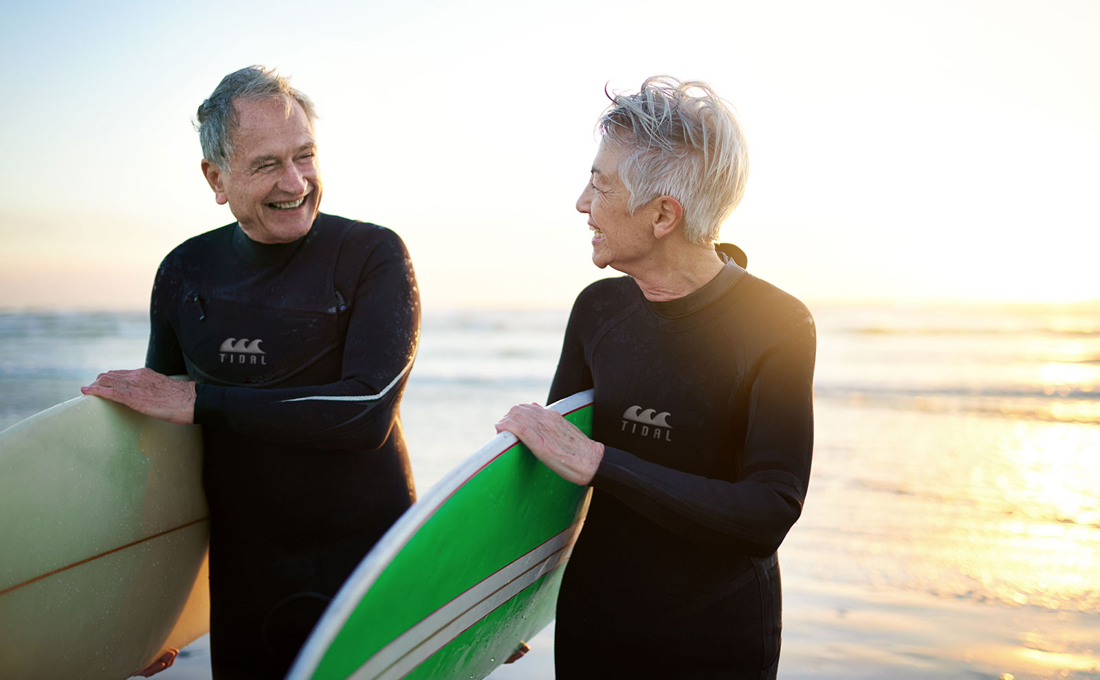 senior couple surfing at the beach